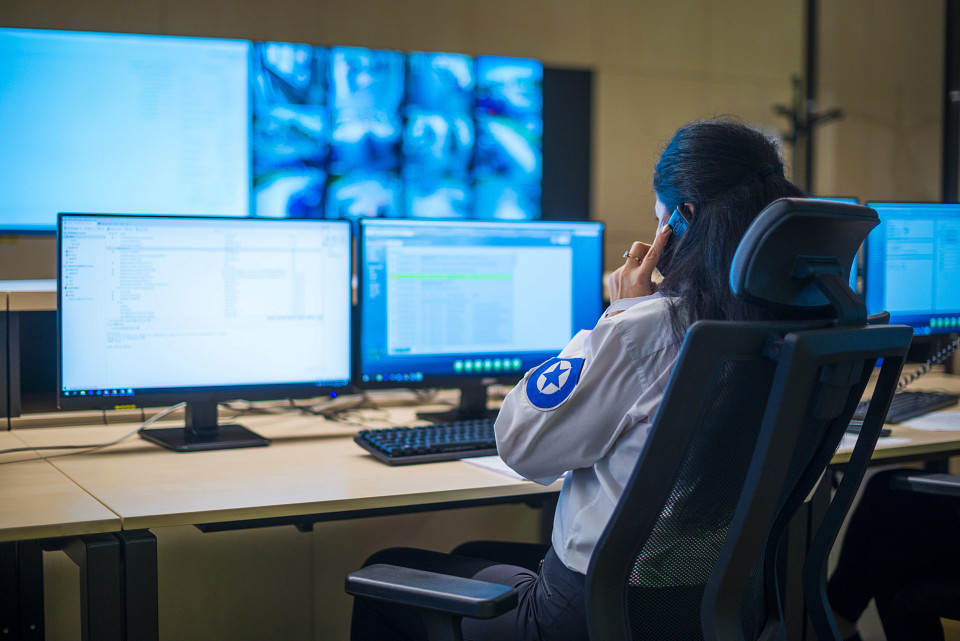 Politie-operator die naar gegevens op een desktop kijkt
