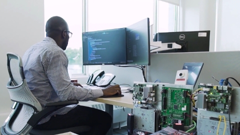 Operator looking at their desktop with security hardware near his work desk